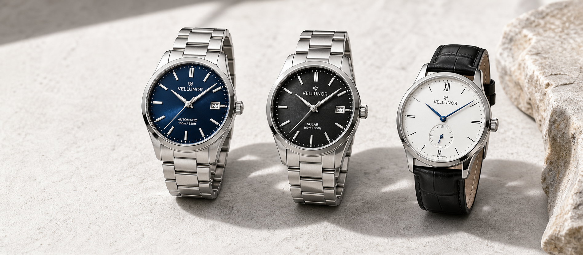 Three original Vellunor watches on a light stone surface